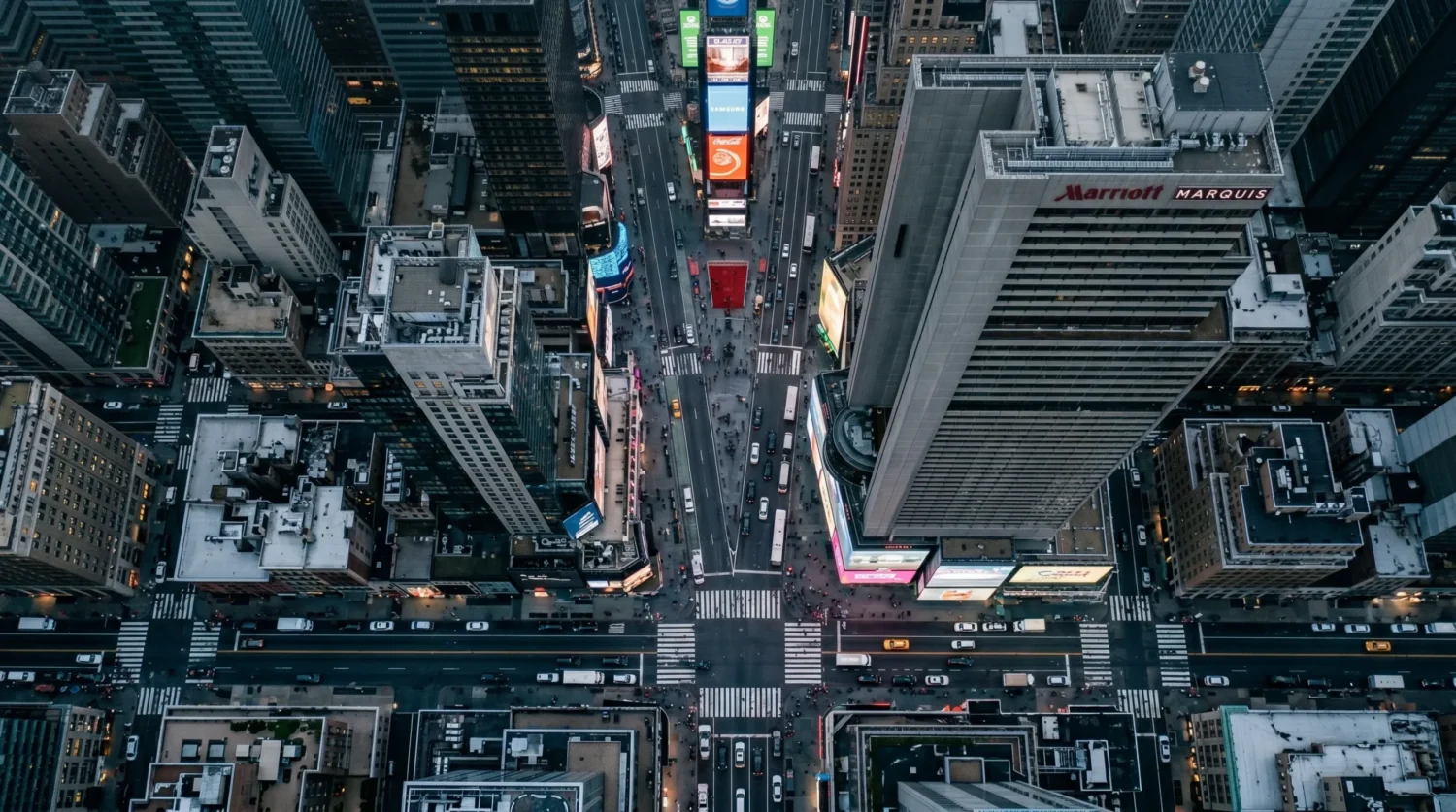 Evening aerial view of Times Square in New York City with busy streets and glowing billboards